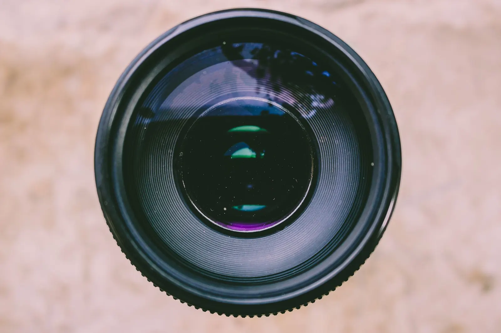 Detailed view of a camera lens capturing light and reflections, showcasing optical technology.